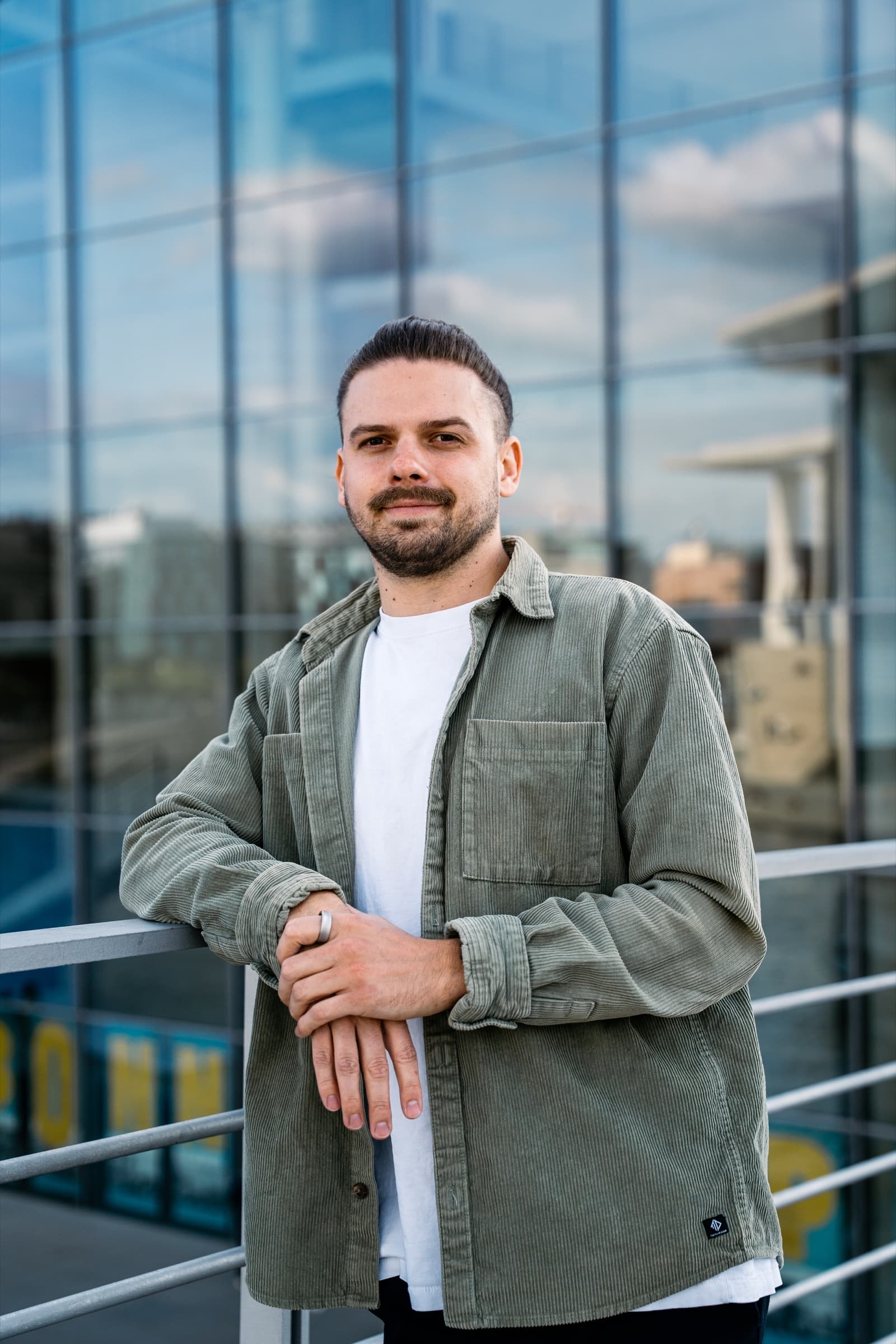 Businessporträt von Phil Radtke vor einer Glasfassade
