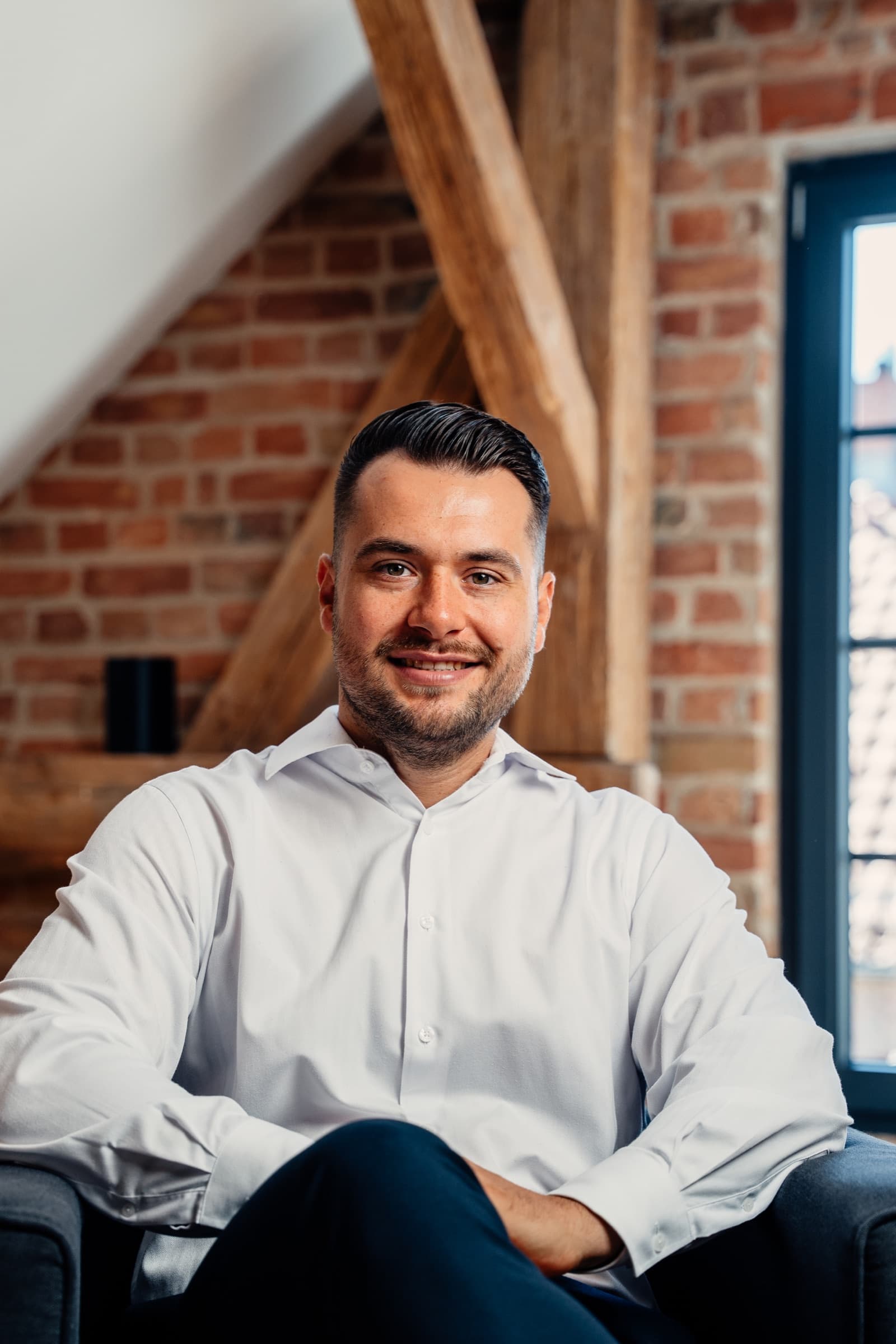 Businessporträt eines Teammitglieds vor sichtbarem Fachwerk